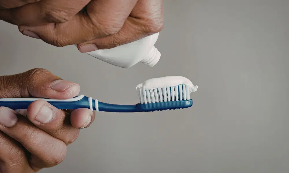 Applying toothpaste to a toothbrush for daily oral hygiene and dental care routine