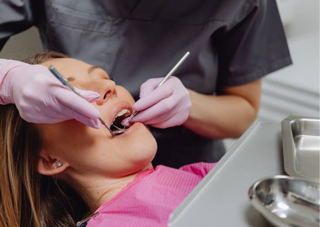 Patient receiving a dental examination while discussing restorative options, illustrating the evaluation process when comparing crowns and veneers.