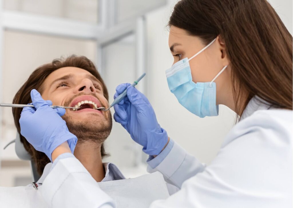 Dentist examining a patient's porcelain veneers during a routine checkup to help maximize porcelain veneers lifespan.