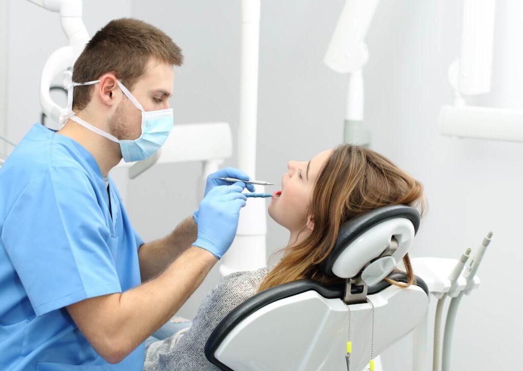 Dentist performing tooth bonding on a patient to restore a chipped tooth and improve the appearance of the smile.